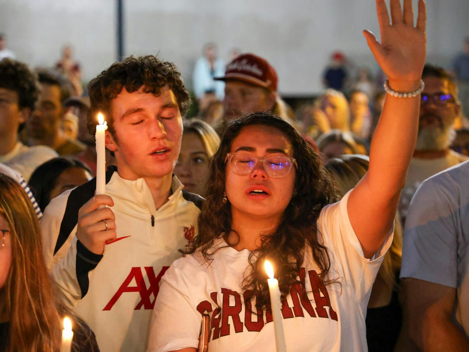 A couple embrace while holding candles at the vigil for Charlie Kirk on Sept. 15, 2025. Dozens of USC students and Columbia residents gathered on Greene Street to host an impromptu vigil for the slain founder of TPUSA.