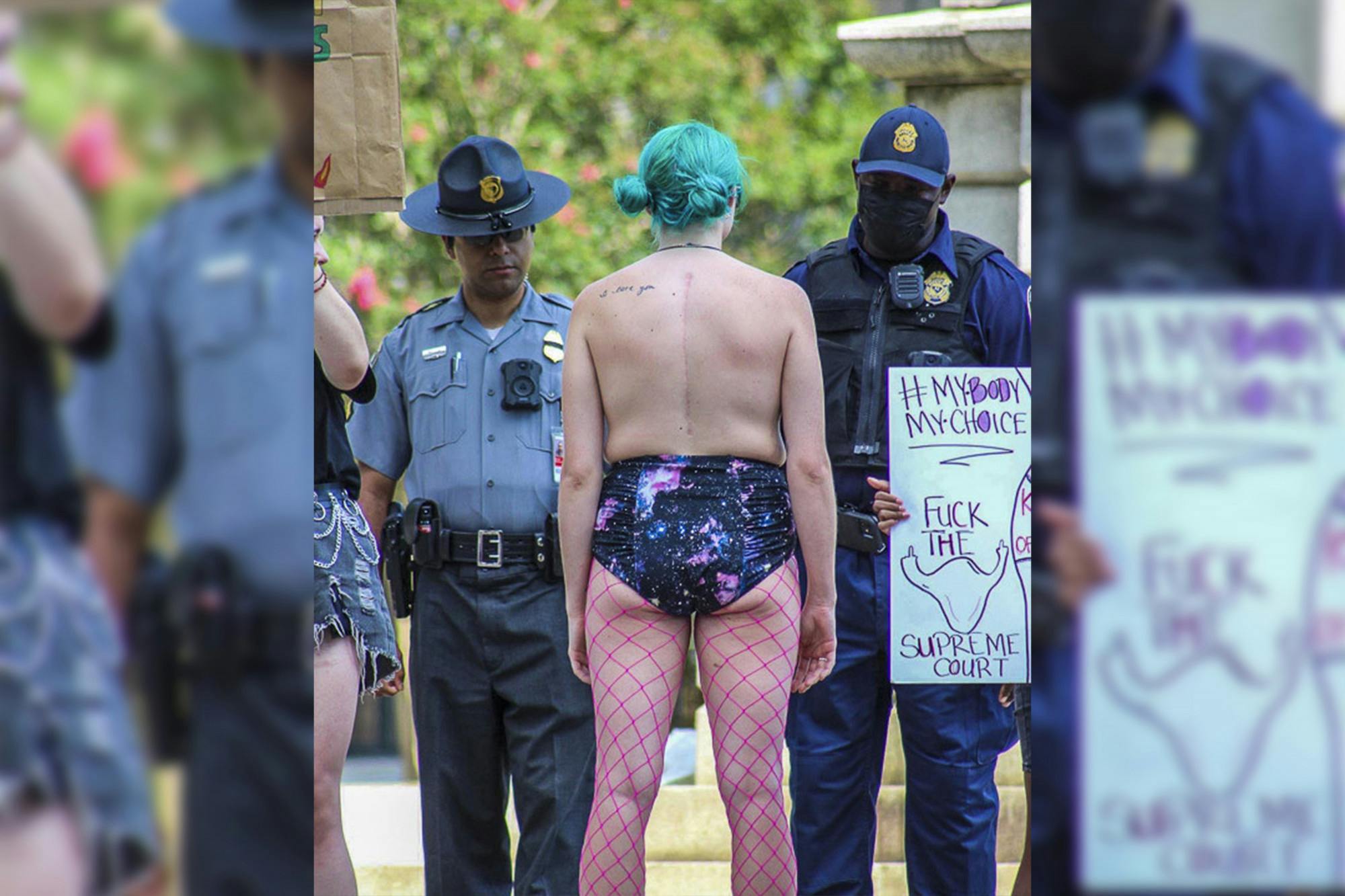 A protester stands in front of City of Columbia police officers amongst other protestors holding up pro-abortion signs during the Dobbs v. Jackson protest at the South Carolina Statehouse on June 25, 2023. The protest came as a response to the overturning of the landmark Roe v. Wade case earlier that June.