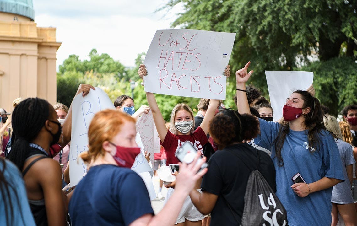 A student holds a sign that says “UofSC hates racists” while protesting Jim Gilles' presence on Greene Street Friday. This was one of many signs that were created on Greene Street after one person brought supplies.