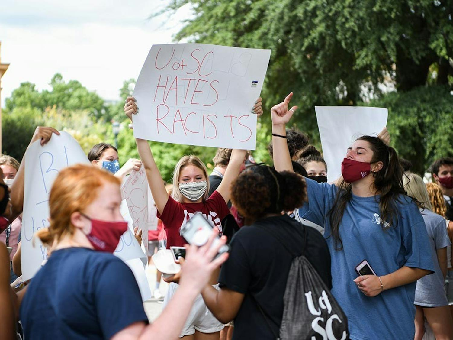 A student holds a sign that says “UofSC hates racists” while protesting Jim Gilles' presence on Greene Street Friday. This was one of many signs that were created on Greene Street after one person brought supplies.