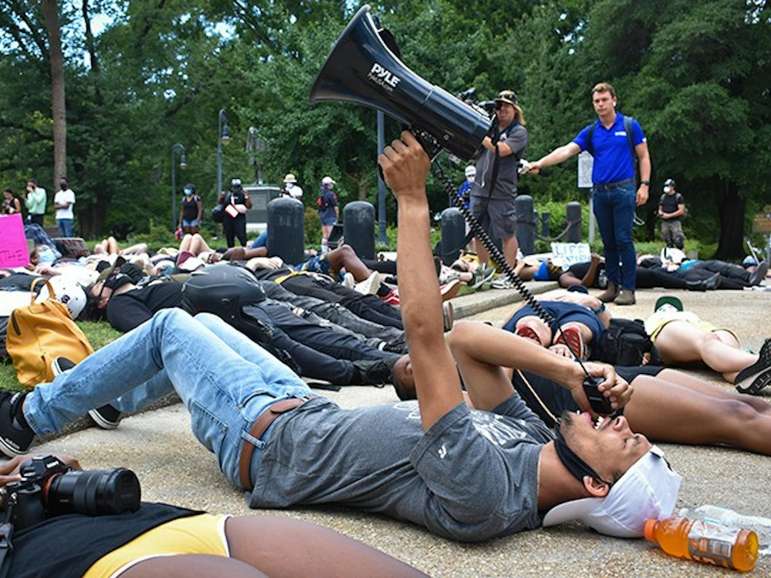Protest organizer Lawrence Nathaniel holds a megaphone as he leads the "Die-In" on Monday in front of the Statehouse.