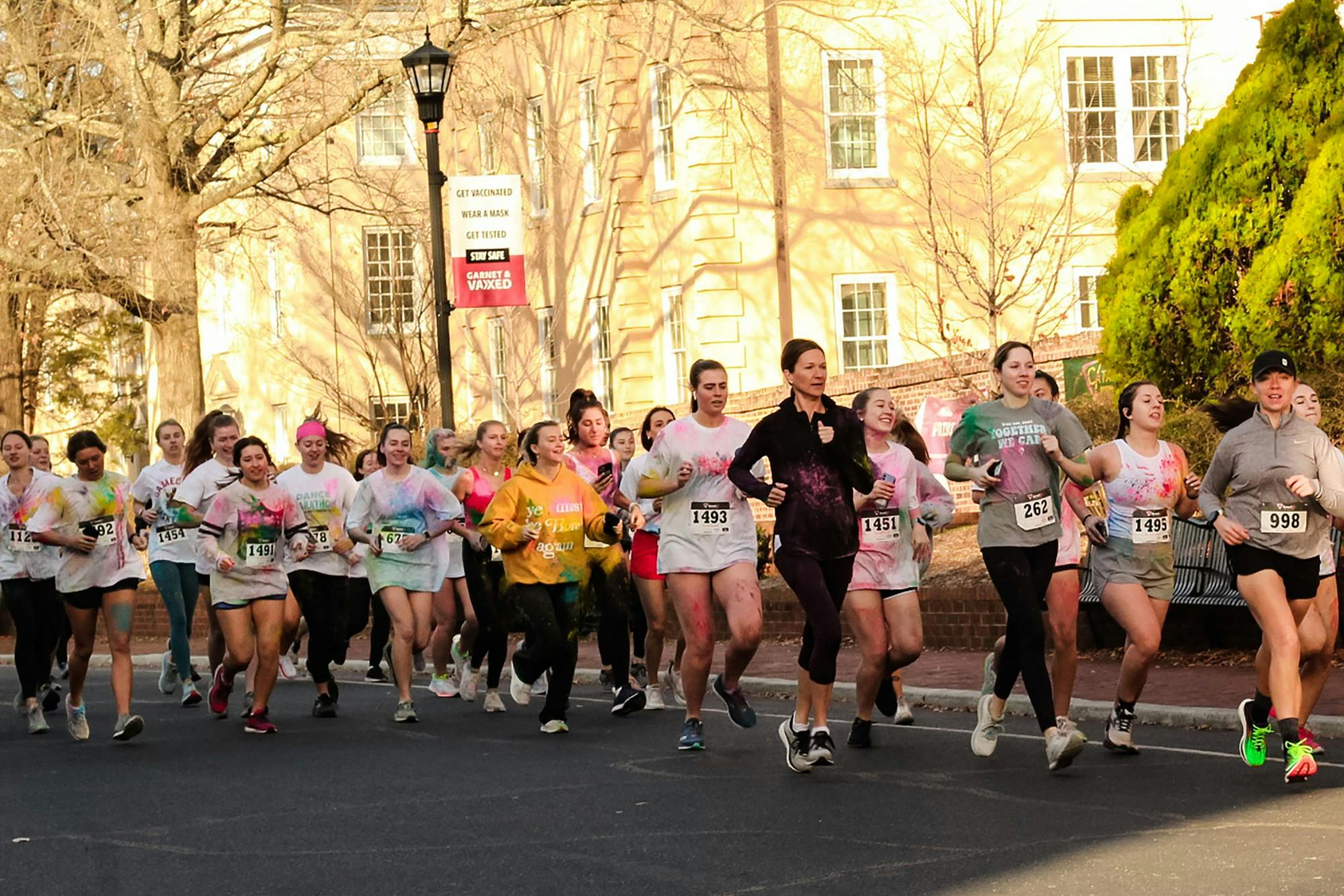 Group of participants in Dance Marathon's annual 5K marathon jog down Greene Street on Saturday, Feb. 26, 2022. Participants of USC Dance Marathon's annual 5K race ran the race covered in colorful clothing too, as part of this edition's "color run."