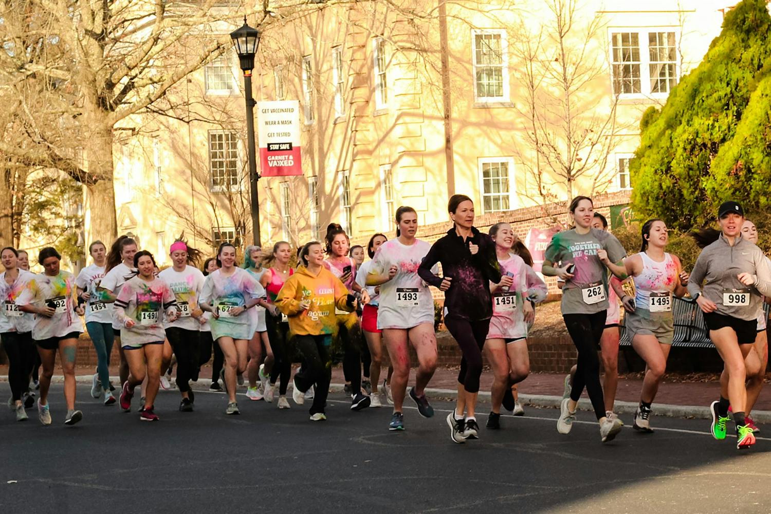 Group of participants in Dance Marathon's annual 5K marathon jog down Greene Street on Saturday, Feb. 26, 2022. Participants of 鶹С򽴫ý Dance Marathon's annual 5K race ran the race covered in colorful clothing too, as part of this edition's "color run."