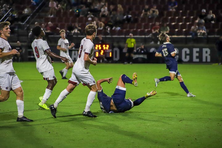A Queens player falls during the matchup with South Carolina on Sept. 20, 2022. Queens received three yellow cards during the game and the Gamecocks received two.