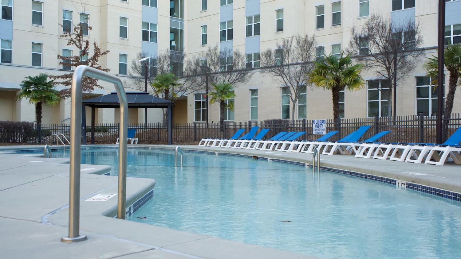 A pool with several while and blue chairs sits at 650 Lincoln, a university affiliated apartment, on March 10, 2024. The Daily Gamecock interviewed 20 students from Park Place and 650 Lincoln to get their thoughts on these building's amenities.