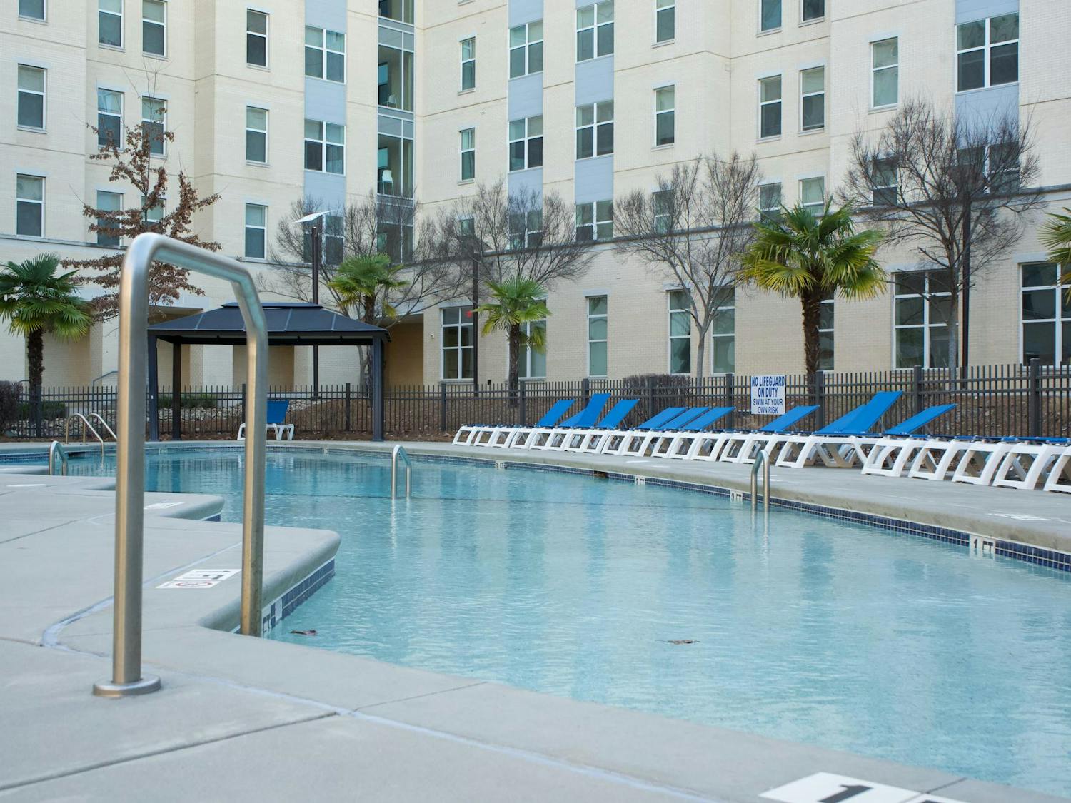A pool with several while and blue chairs sits at 650 Lincoln, a university affiliated apartment, on March 10, 2024. The Daily Gamecock interviewed 20 students from Park Place and 650 Lincoln to get their thoughts on these building's amenities.