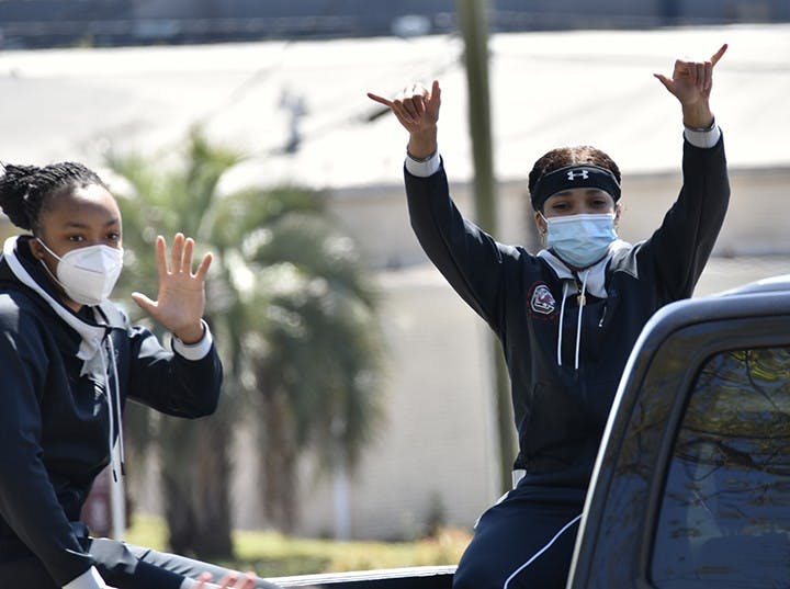 Freshman guard Eniya Russell and junior guard Destanni Henderson wave and give a “spurs up” to fans celebrating their performance and progress in the NCAA Tournament.