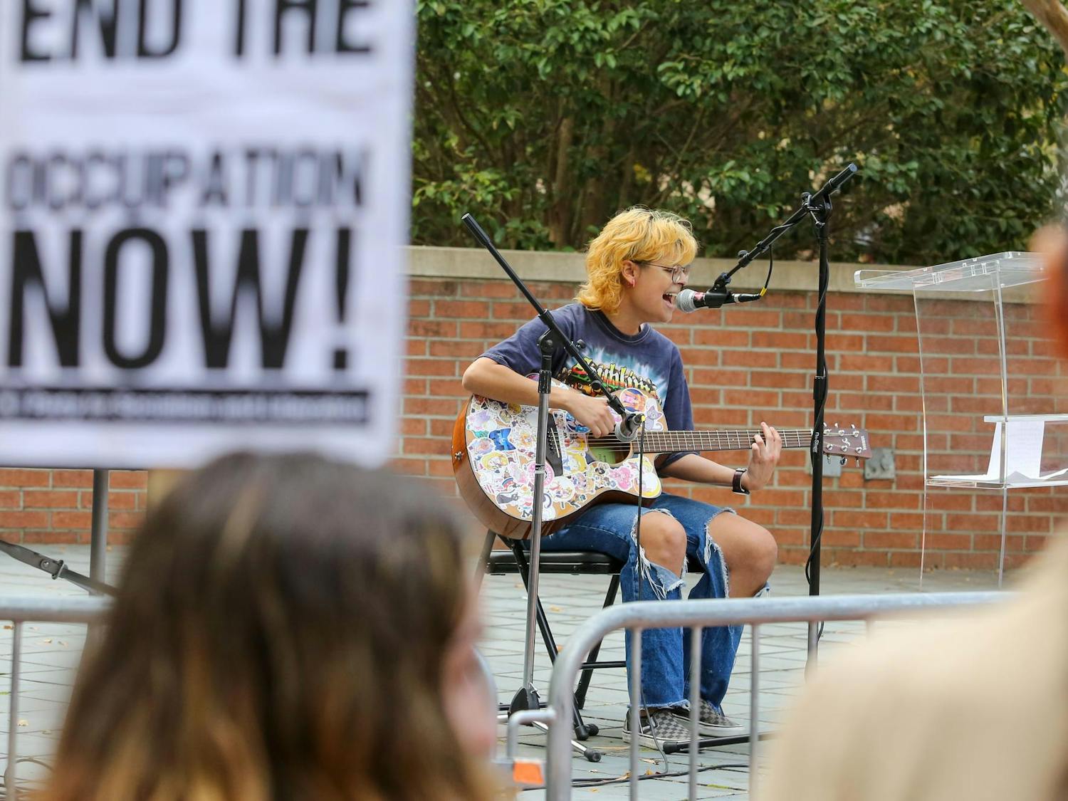 Third-year sociology student Andres Gonzalez sings an original song during the walkout for Palestine on the Russell House Patio on Nov. 9, 2023. Gonzalez was one of many speakers, who called for ceasefire between Israel and Hamas.