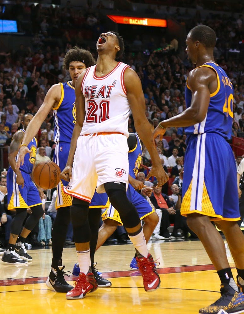 The Miami Heat&apos;s Hassan Whiteside, middle, reacts after dunking during the first quarter against the Golden State Warriors at the AmericanAirlines Arena in Miami on Wednesday, Feb. 24, 2016. (David Santiago/Miami Herald/TNS)