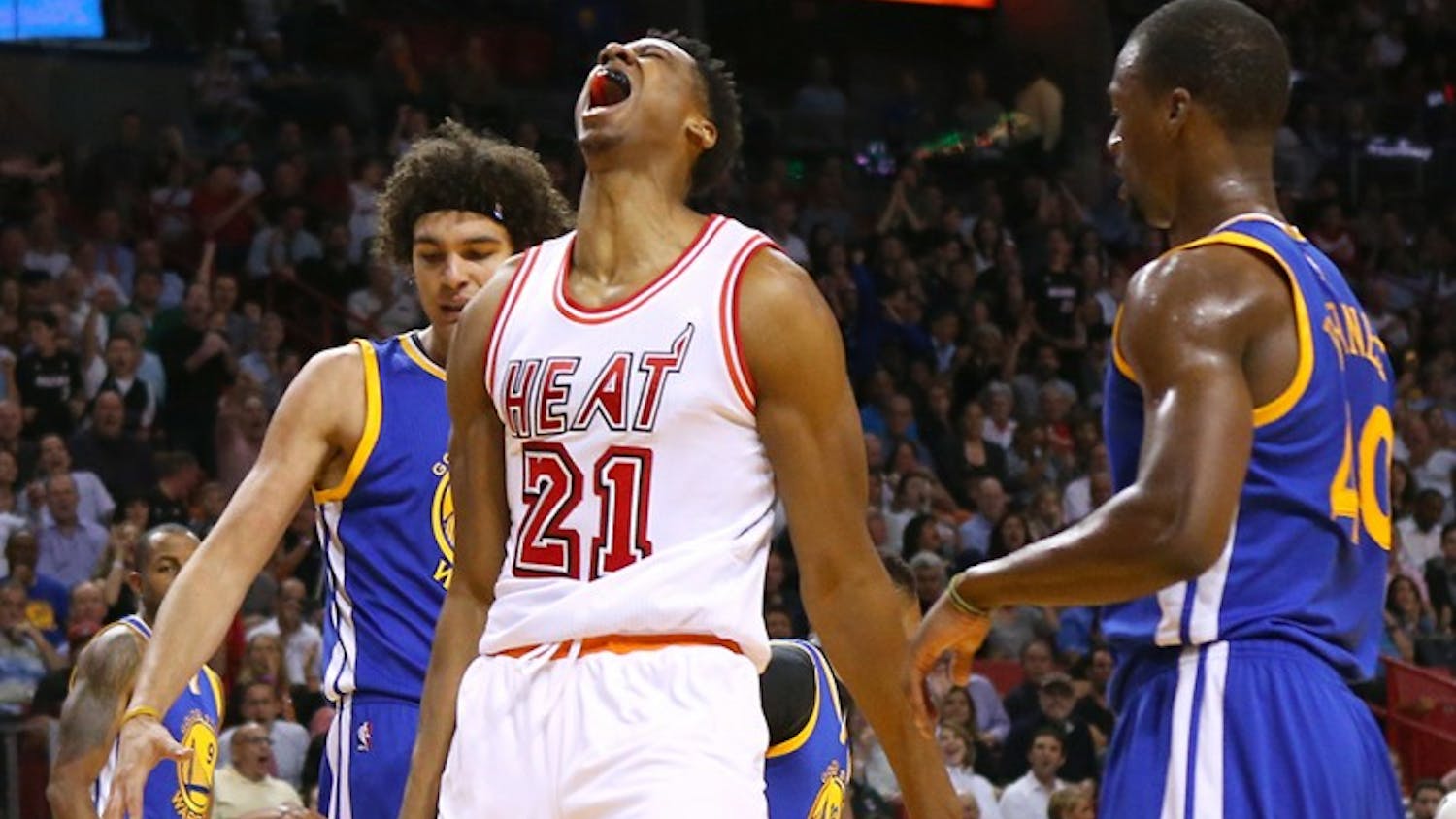 The Miami Heat&apos;s Hassan Whiteside, middle, reacts after dunking during the first quarter against the Golden State Warriors at the AmericanAirlines Arena in Miami on Wednesday, Feb. 24, 2016. (David Santiago/Miami Herald/TNS)