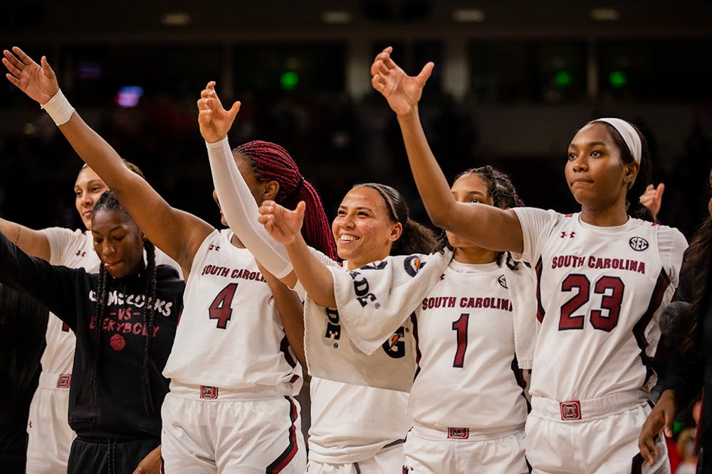 The women’s basketball team smiles and lifts their “cups” in celebration after defeating Clemson by over 30 points.