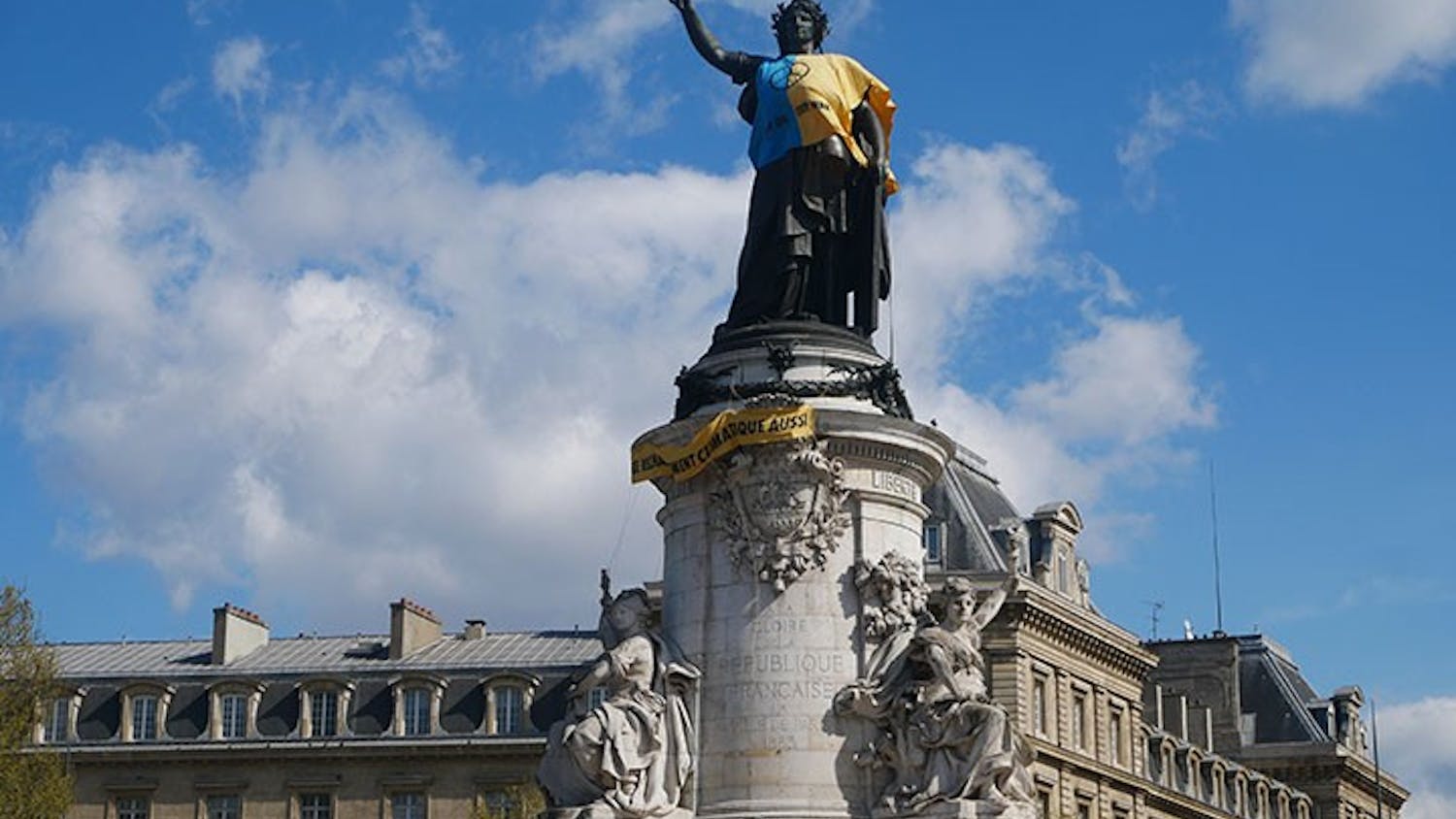 A statue of Marianne, the embodiment of the French Republic, stands over the Place de la République in Paris, France, draped with the Ukrainian flag and the phrase ‘stop oil, stop war.’