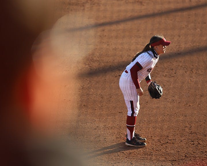 &nbsp;Freshman infielder Maddie Gallagher watches the batter, ready to catch the ball, while her teammate prepares to pitch.