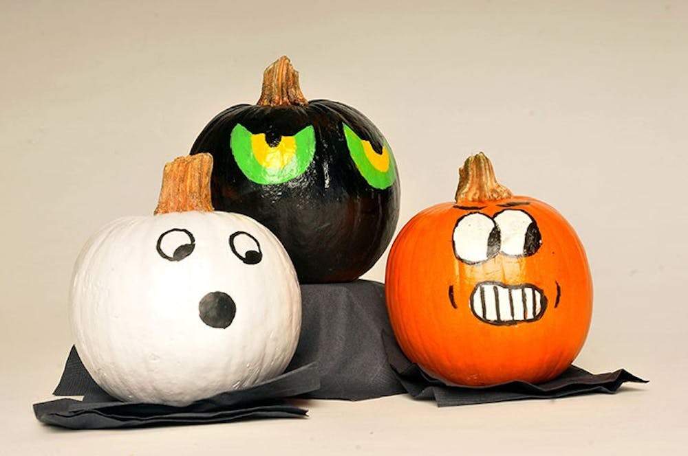 A set of three painted pumpkins on display. Painting a pumpkin is sometimes used as an alternative to carving it.
