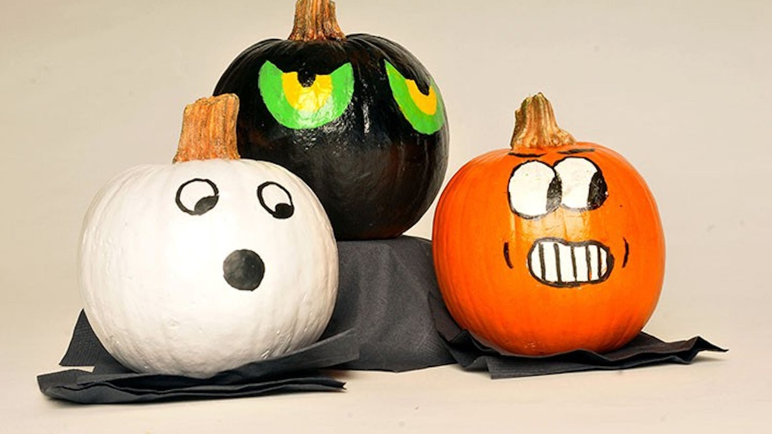 A set of three painted pumpkins on display. Painting a pumpkin is sometimes used as an alternative to carving it.
