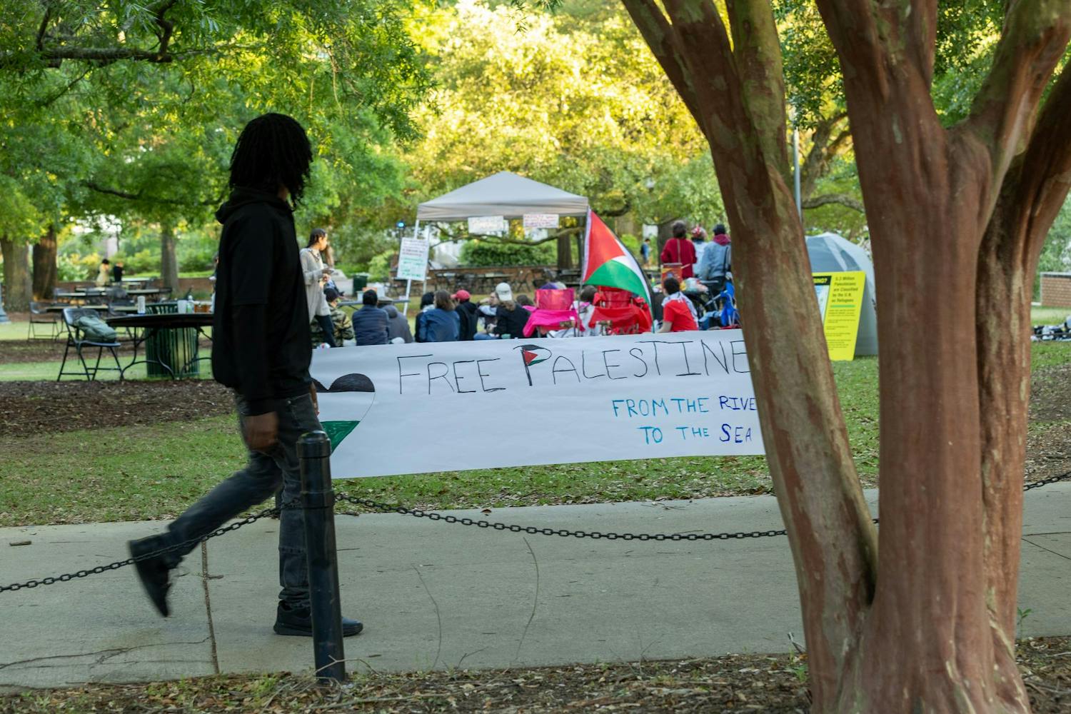 Students at the University of South Carolina walk around campus while attending their final day of classes for the spring 2024 semester. A group of protestors gathered on Davis Field during the last day of classes.