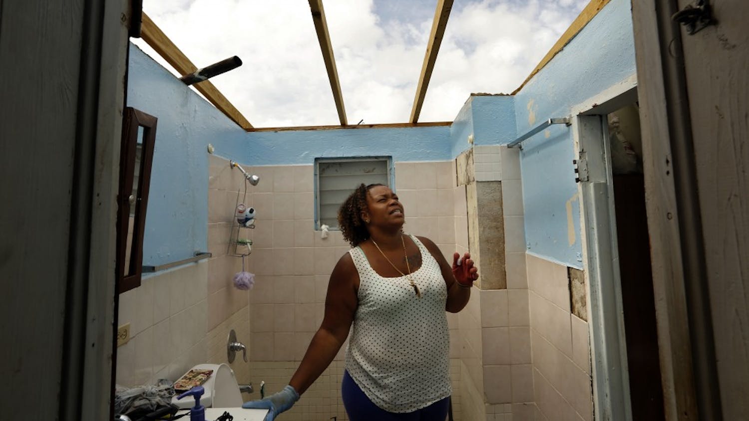 Adele Thomas is grateful that her family survived Hurricane Irma after it roared through her house, ripping the roof off and destorying all the contents. She is working to cover the roof with plastic, but the bathroom hasn't been covered yet, nor is there running water or electricity on Friday, Sept. 15, 2017. (Carolyn Cole/Los Angeles Times/TNS)