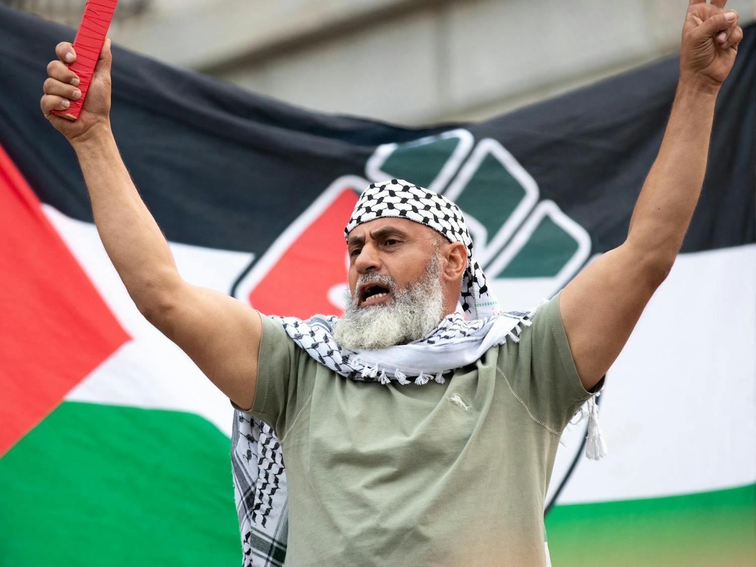 An attendee of the Free Palestine Emergency Demonstration raises their arms after a speech made by one of the organizers of the rally. This rally was held by the North and South Carolina Party for Social Liberation on Oct. 17, 2023 on the Statehouse grounds in Columbia, S.C.