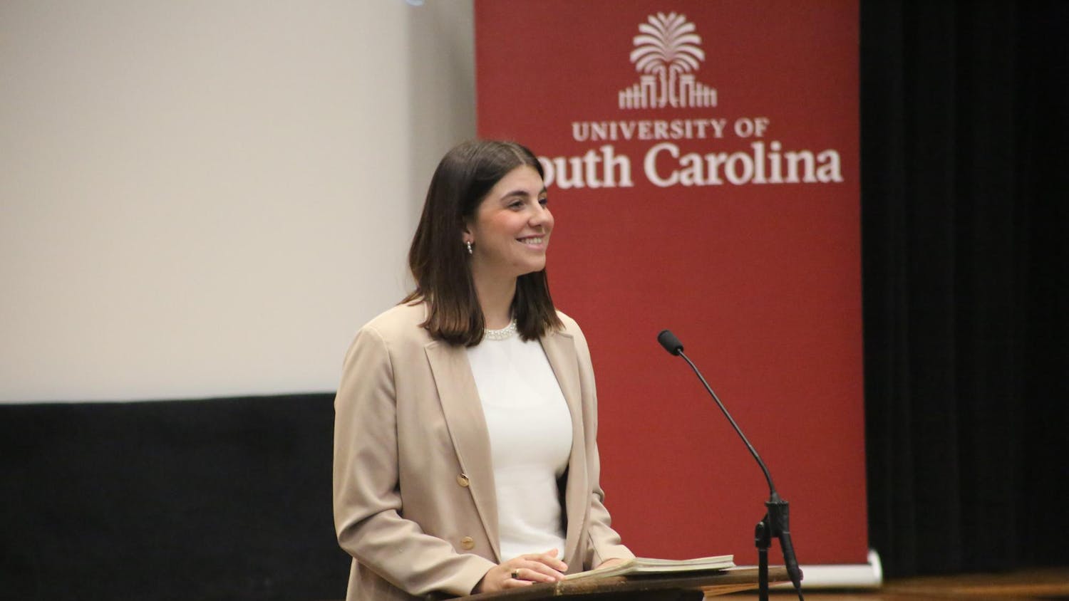 Student Body President Courtney Tkacs reports on the Stuff-a-Bus event and encourages the other senators to attend during the Student Body President Report period at the Russell House Theater on Nov. 5, 2025. Tkacs added that senators wanting to volunteer should bring non-perishable food items and wear their Student Government shirts.