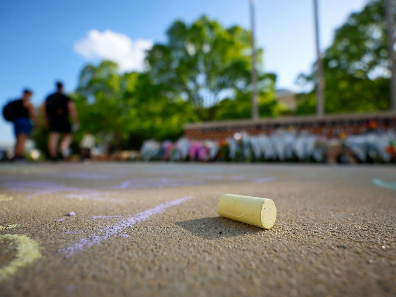 A piece of chalk lies on the ground outside the memorial for Nathaniel "Nate" Baker on April 3, 2025. Students left messages and flowers in memory of Baker, who was killed in a hit-and-run the previous day.