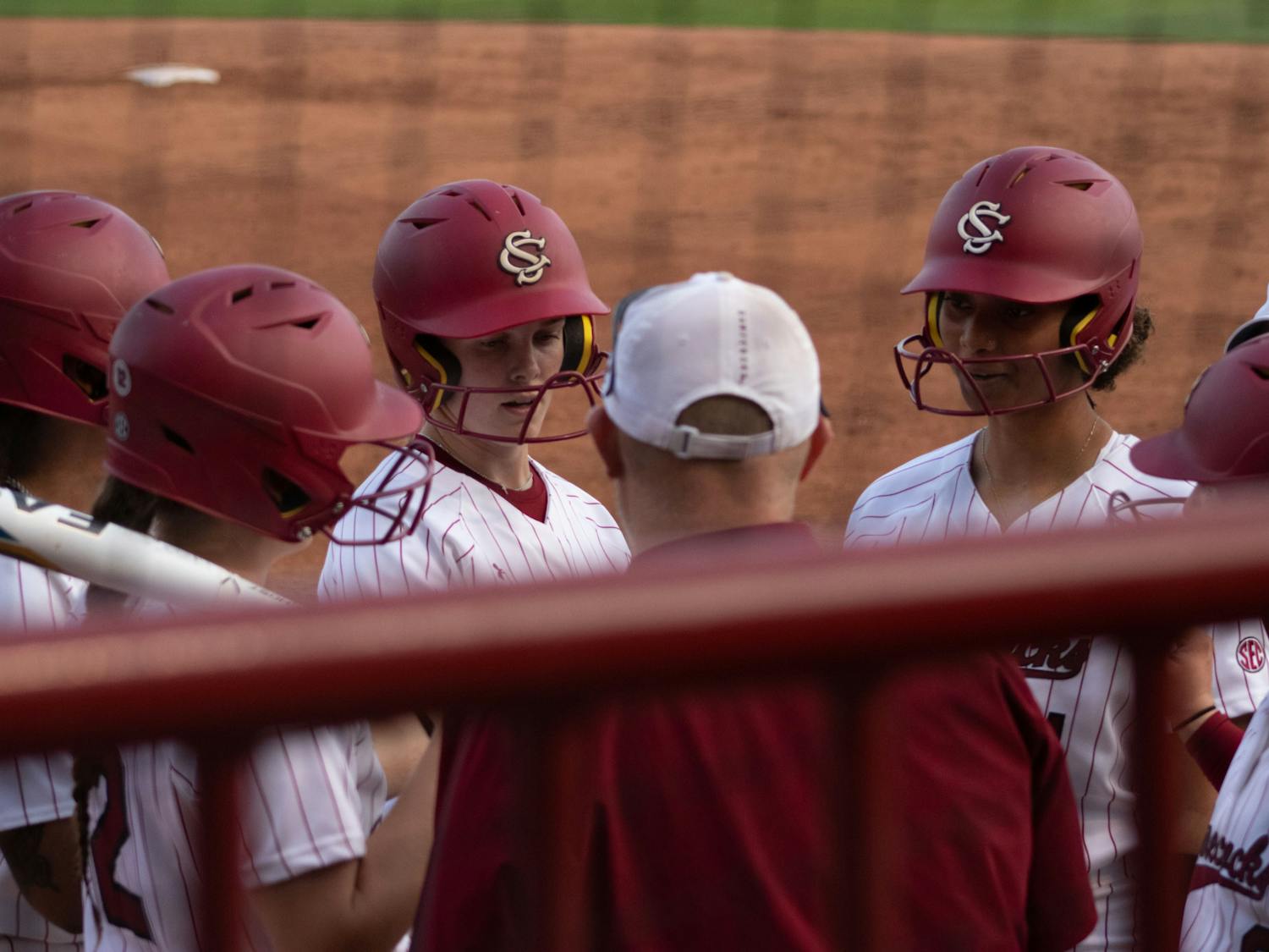 Gamecock softball players gather around assistant coach Josh Bloomer during a timeout in the game against the University of Florida on March 31, 2023, at Beckham Field. The Gamecocks beat the Gators 13-10 in the first game of the series.&nbsp;