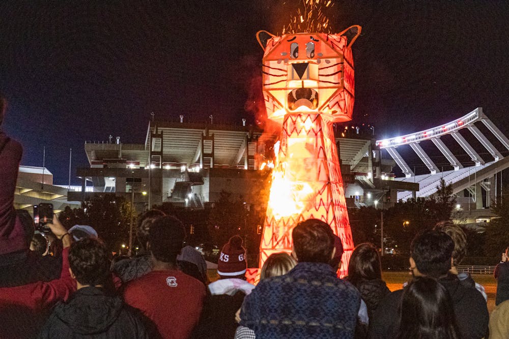 <p>Students watch as a giant wood and steel-beam Tiger bursts in flames during the USC Tiger Burning Ceremony on Nov. 21, 2022. The Gamecocks went on to beat Clemson 31-30 for the first time since 2013.</p>