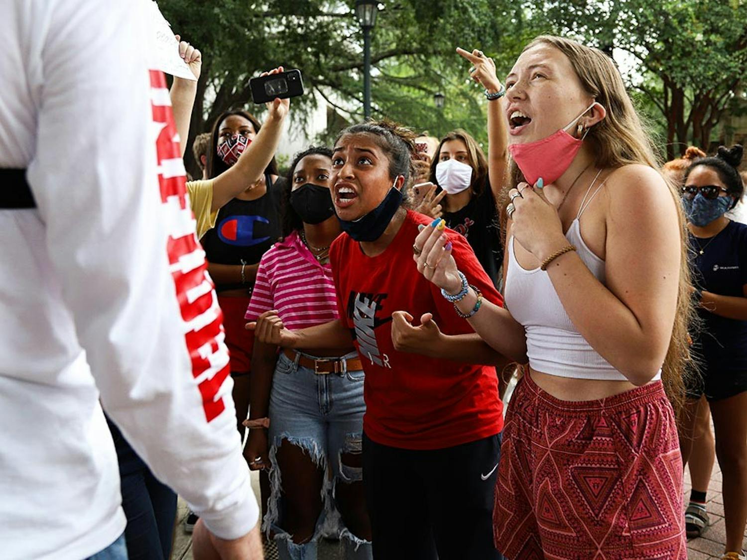 Isabella Jones and a fellow student yell in protest of Jim Gilles' presence on the university’s campus. These students combated remarks made by Jim Gilles, and many students yelled in agreement.