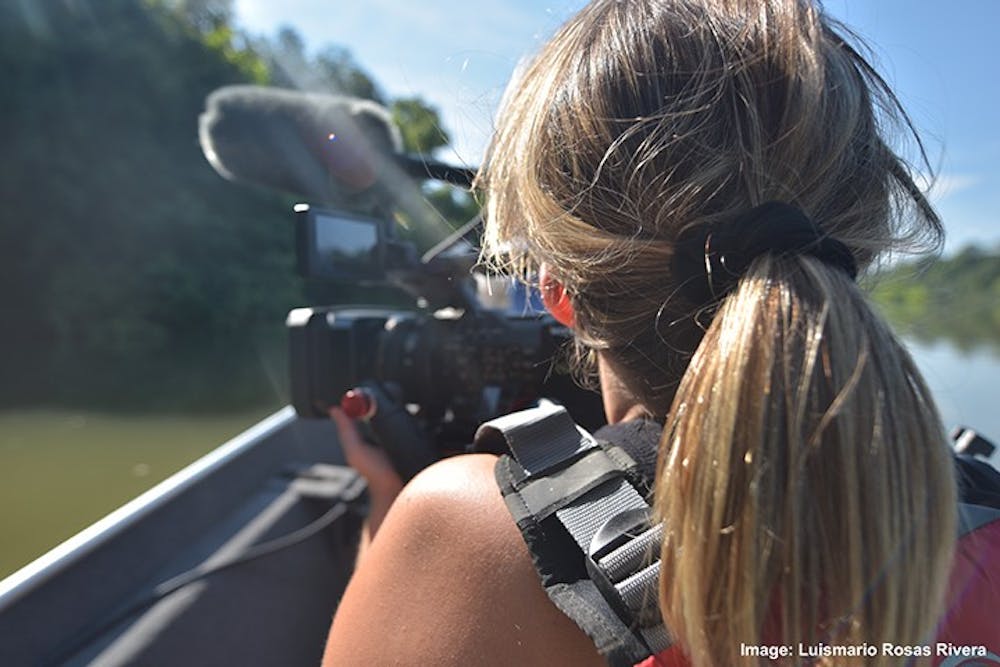<p>Emma Deloughry filming the Congaree River while sitting in a boat.</p>