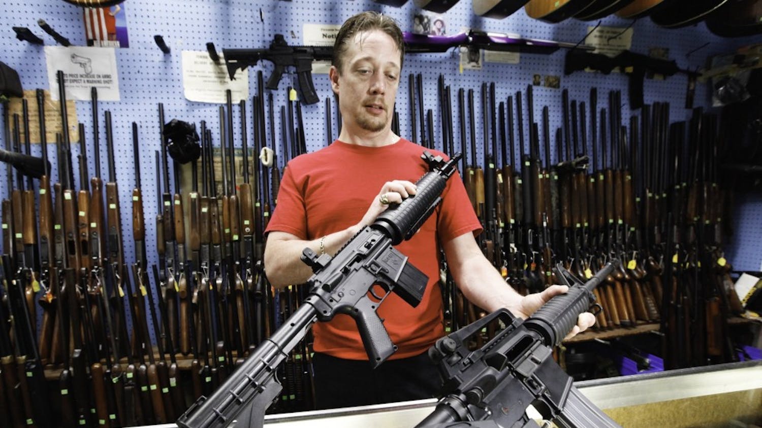 Shawn Bertke, manager of Rich's Pawn Shop in Dayton, Ohio, has two guns for sale that look virtually alike. At left is a $45 Crosman BB gun; the other is a $1,200 real AR-15 rifle. (Chris Stewart/Dayton Daily News/MCT)