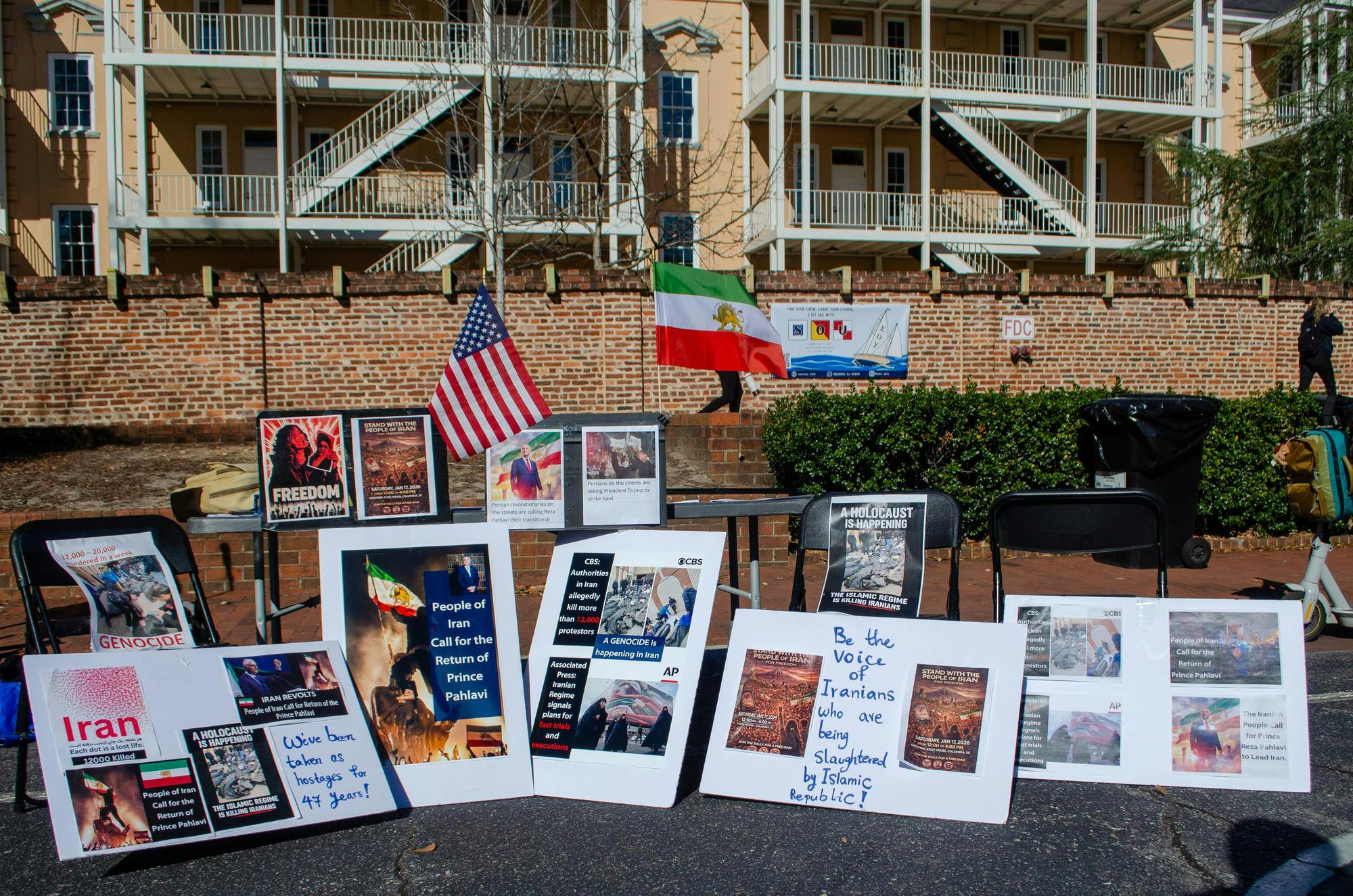 A demonstration in support of protestors in Iran takes place outside the Russell House on Greene Street in Columbia, South Carolina, on Jan. 15, 2026. Signs accuse the Islamic Republic of genocide and support the return of Crown Prince Reza Pahlavi, who is in exile in the United States.