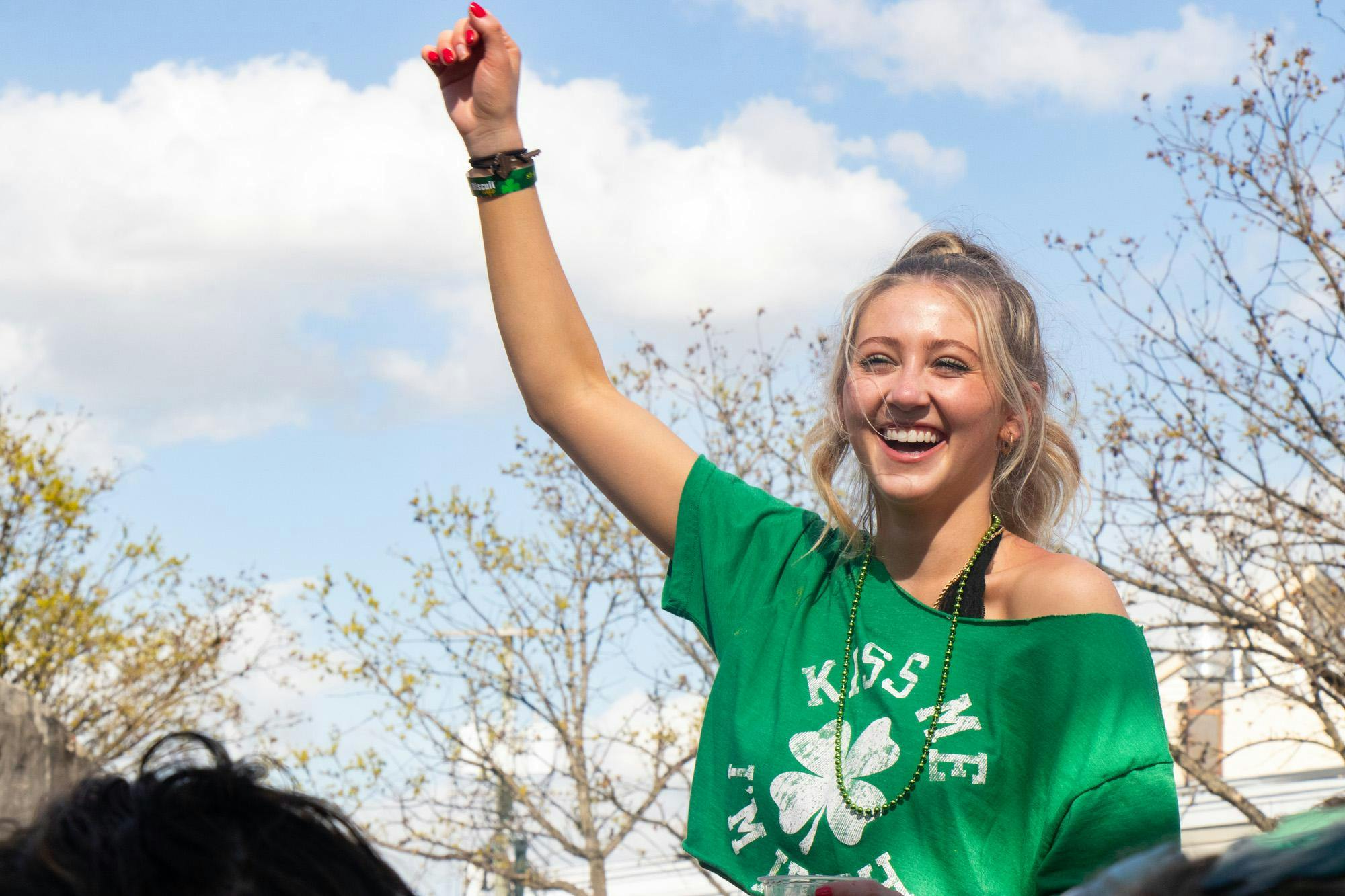 Fourth-year student Bri Conner cheers while sitting on top of another spectator's shoulders during Conner Smith’s performance at the Saluda Stage during St. Pat's in Five Points in Columbia, South Carolina on March 16, 2024. Smith, a country singer from Nashville, Tennessee, was one of many performers to take the stage during Saturday’s festival.