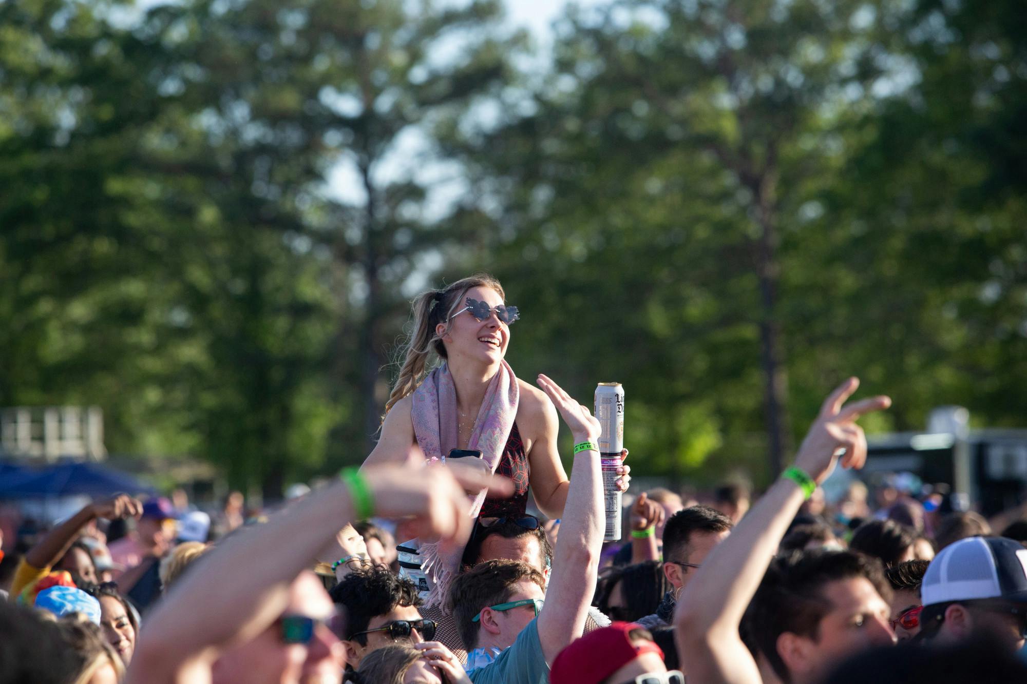A fan rides her friend’s shoulders during Champagne Drip’s Hidden City Music Festival set on April 22, 2023. The day was predicted to have thunderstorms, but that failed to come to true, giving festival goers a perfect sunny and partly cloudy day.  