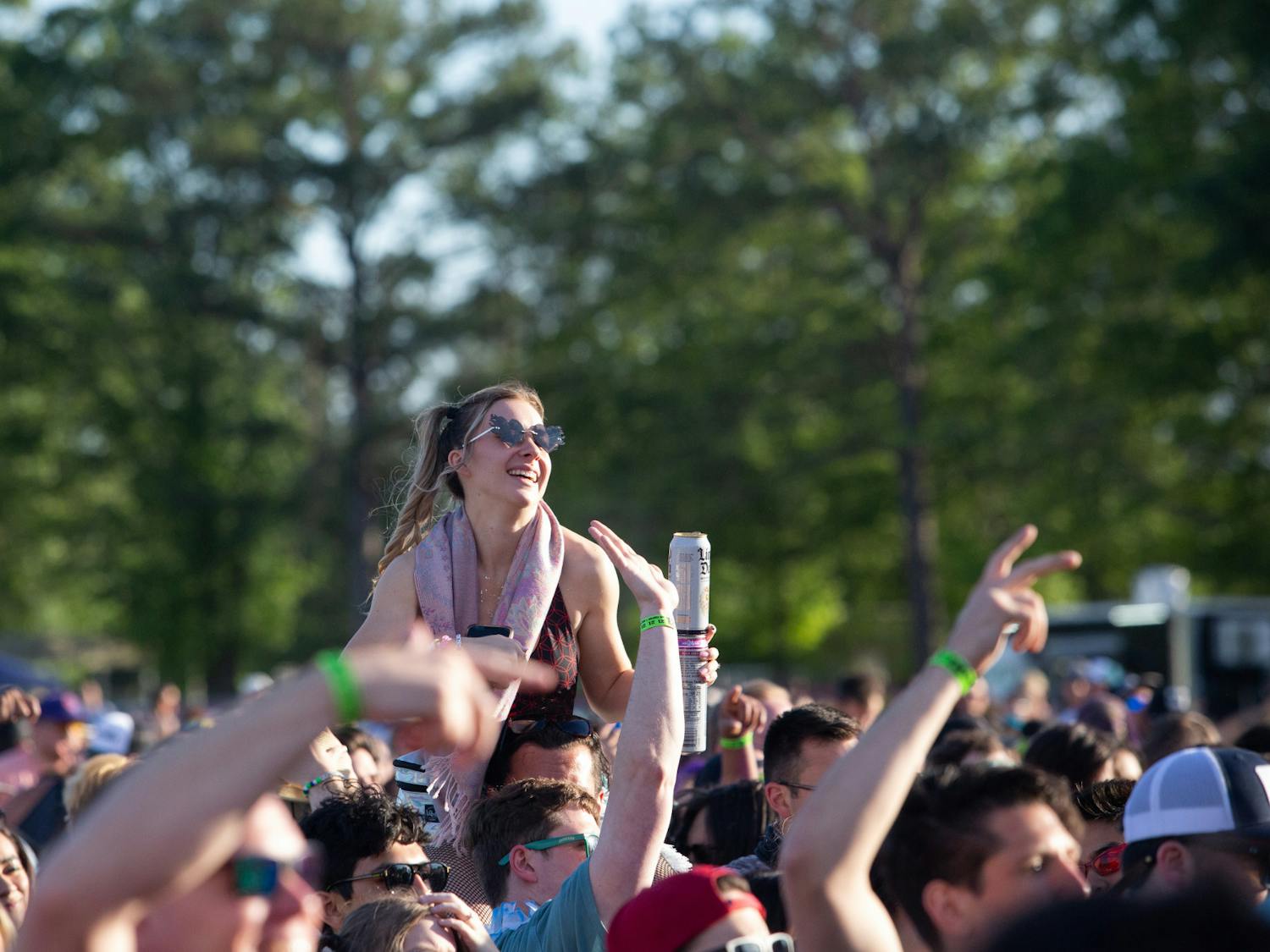 A fan rides her friend’s shoulders during Champagne Drip’s Hidden City Music Festival set on April 22, 2023. The day was predicted to have thunderstorms, but that failed to come to true, giving festival goers a perfect sunny and partly cloudy day.  