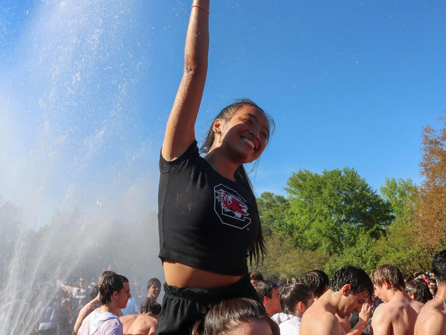 A University of South Carolina student sits on a friend's shoulders and poses for a picture during celebrations following the South Carolina women's basketball team's NCAA National Championship win on April 7, 2024. Students converged in the Thomas Cooper Fountain and Reflecting Pool following the Gamecocks' 87-75 victory over the Iowa Hawkeyes.