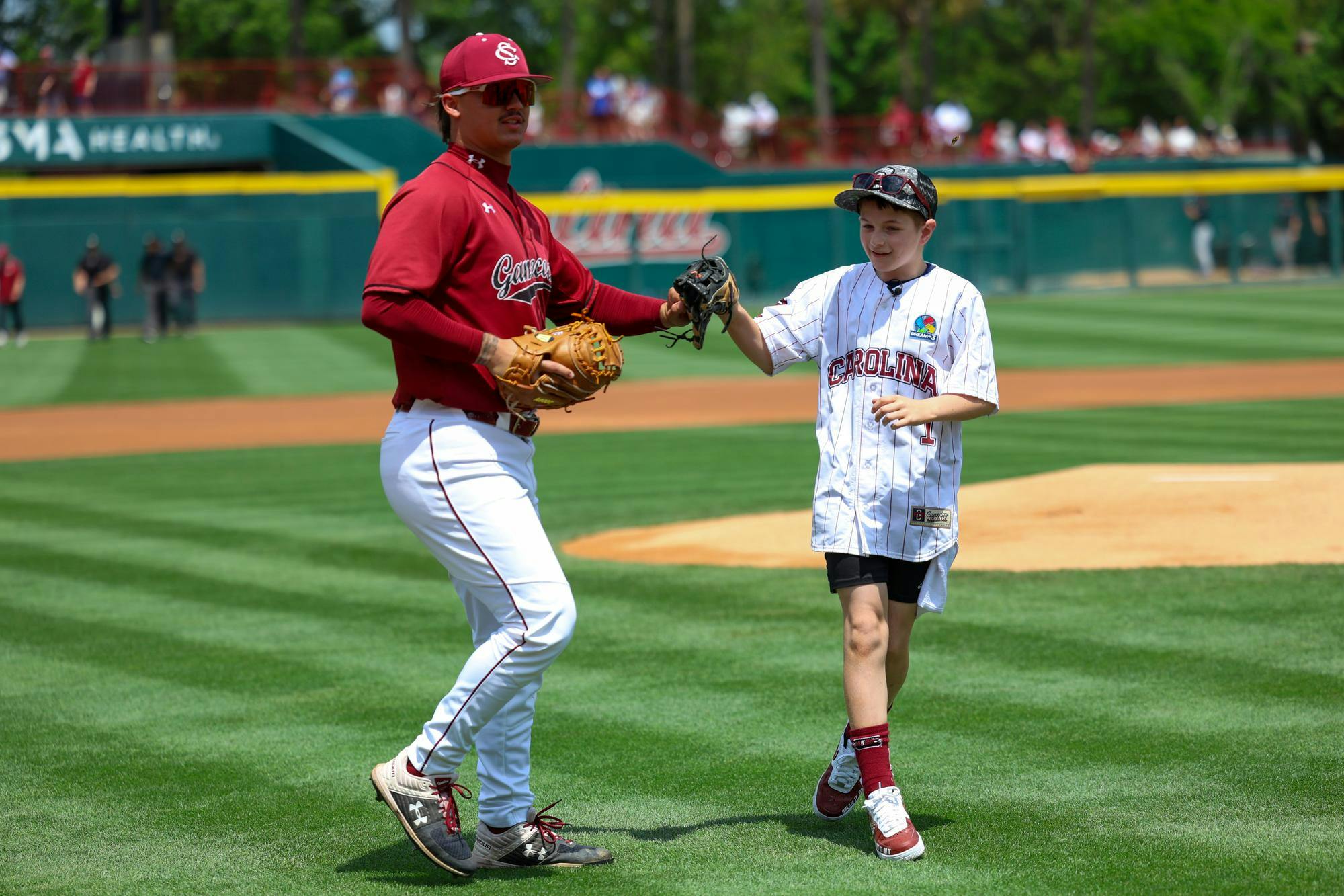 Lexington resident Gabriel Lyons fist bumps junior left-handed pitcher Alex Valentin for South Carolina after throwing out the first pitch at the game against Kentucky on April 25, 2026. Lyons was given the opportunity to throw the pitch by Dream on 3 and its USC affiliate division.