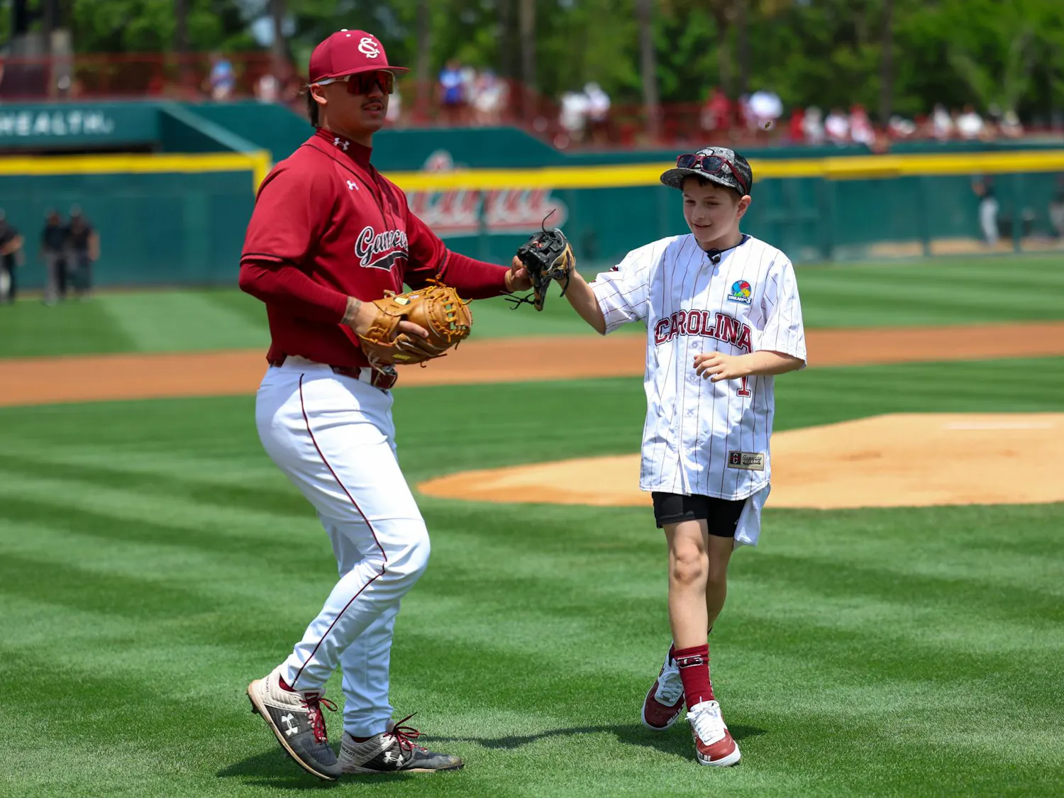 Lexington resident Gabriel Lyons fist bumps junior left-handed pitcher Alex Valentin for South Carolina after throwing out the first pitch at the game against Kentucky on April 25, 2026. Lyons was given the opportunity to throw the pitch by Dream on 3 and its USC affiliate division.