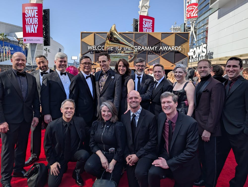 <p>USC music professor and Alarm Will Sound member Michael Harley (far left), kneels on the red carpet at the 2026 Grammy Awards on Feb. 1. Alarm Will Sound won the award for&nbsp;Best Chamber Music / Small Ensemble Performance.</p>