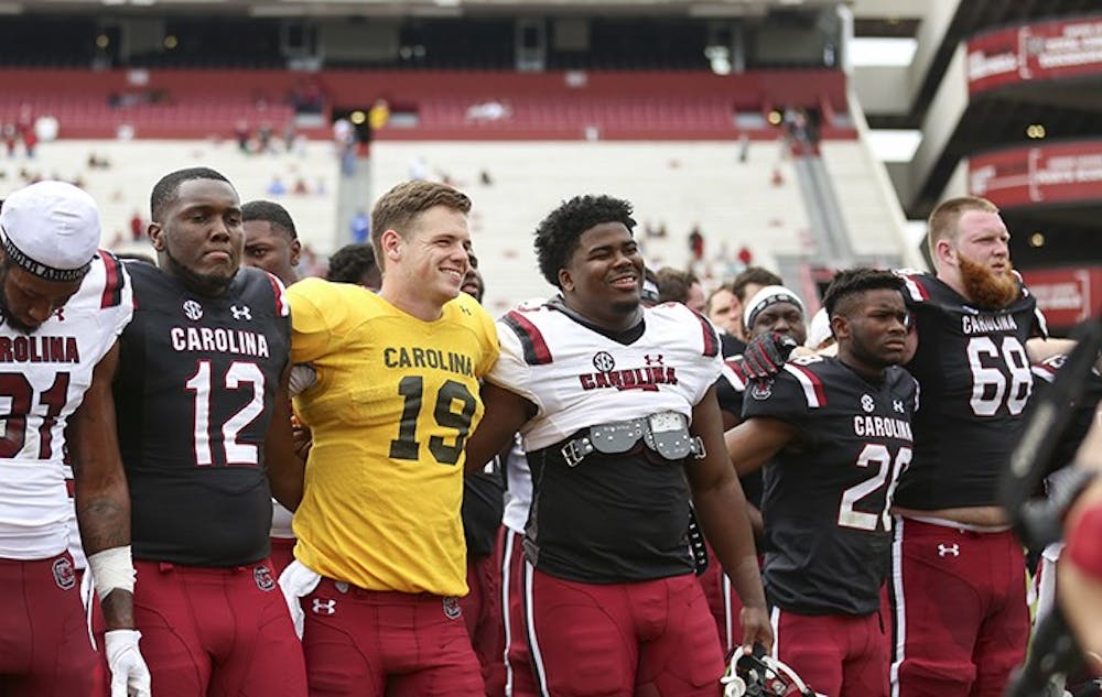 <p>Seniors Jake Bentley and Javon Kinlaw smile during the alma mater following the spring game at Williams-Brice Stadium on Saturday.&nbsp;</p>