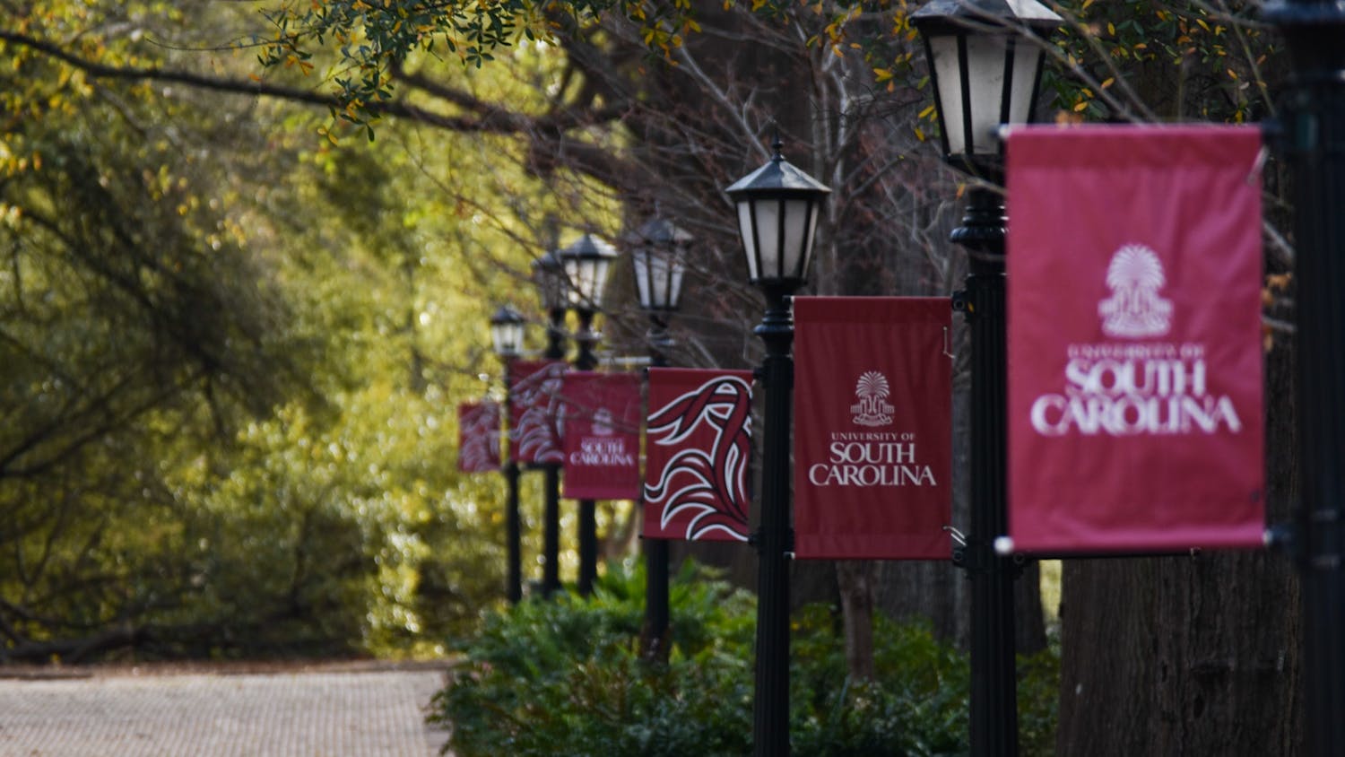USC banners on lamp posts lining the Horseshoe at sunrise. 