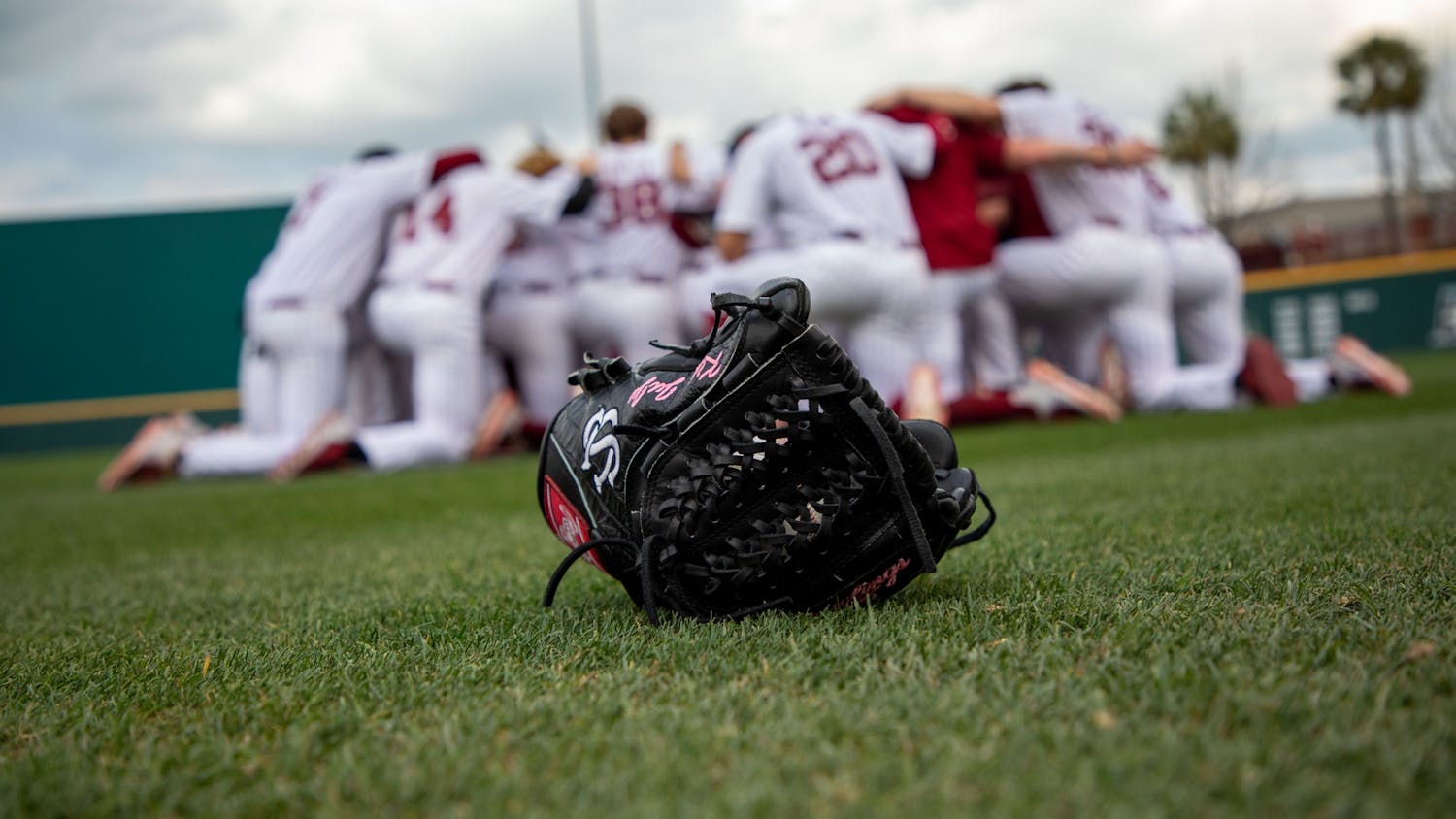 FILE—Closeup of a glove as the South Carolina baseball team huddles before a game against Appalachian State on Tuesday, March 1, 2022.