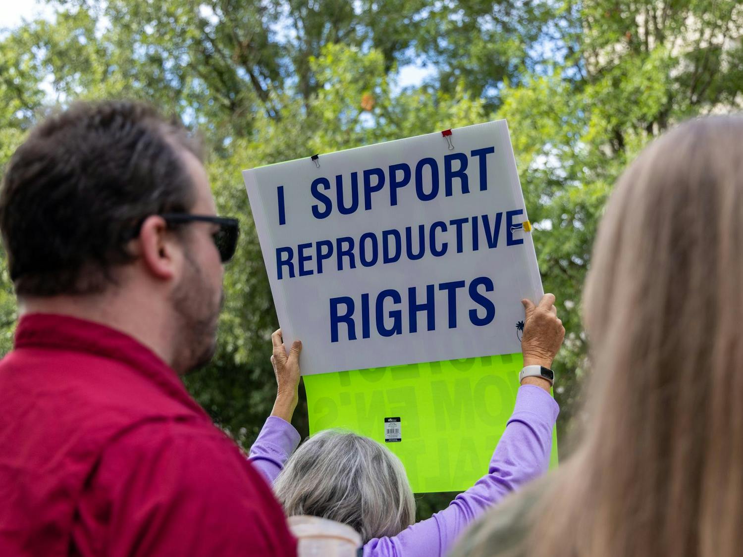A woman holds up a sign reading "I SUPPORT REPRODUCTIVE RIGHTS" outside the Gressette Building during a public hearing on S.B 323 on Oct. 1, 2025. Many residents from across South Carolina came together to both rally outside and provide public commentary on the proposed 6-week abortion ban.