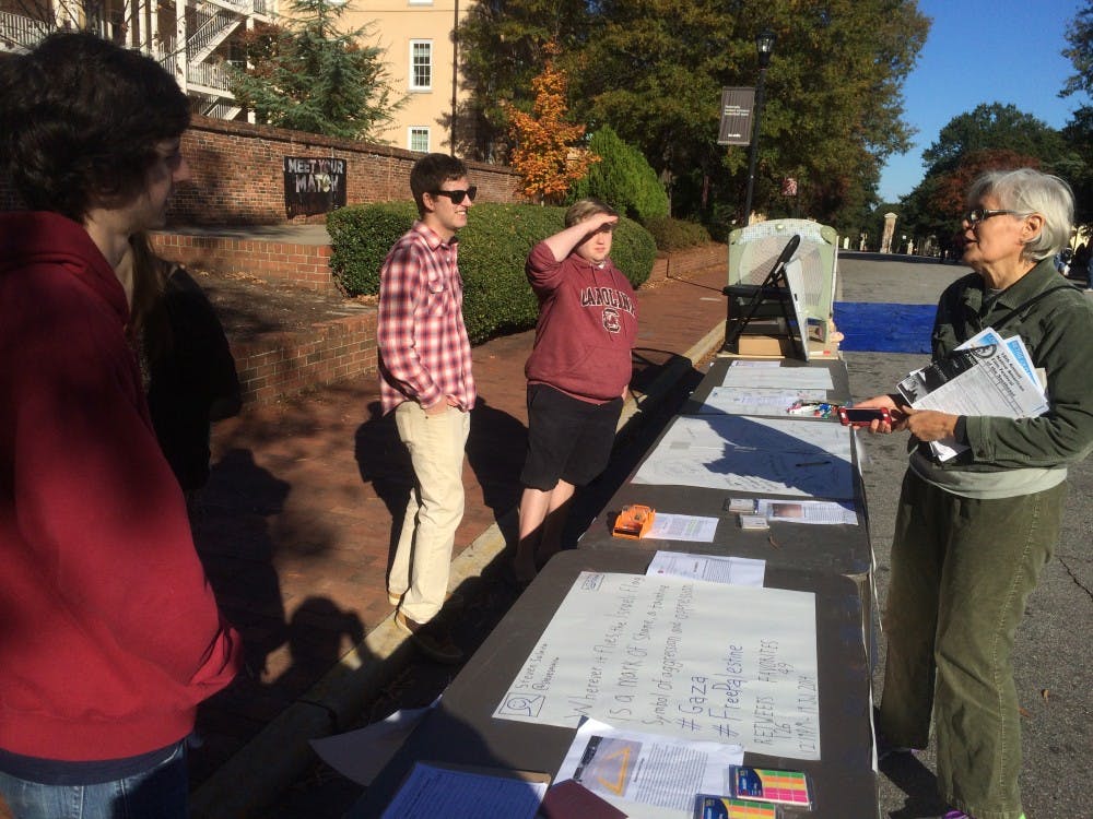 Ross Abbott, the president of the College Libertarians, said that the event was meant to provoke dialogue. Abbott, second from left, speaks with a passerby. 