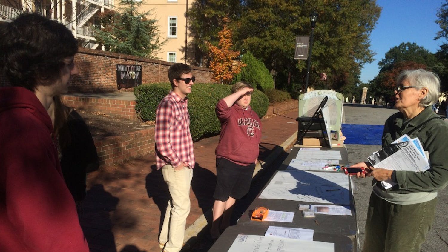 Ross Abbott, the president of the College Libertarians, said that the event was meant to provoke dialogue. Abbott, second from left, speaks with a passerby. 