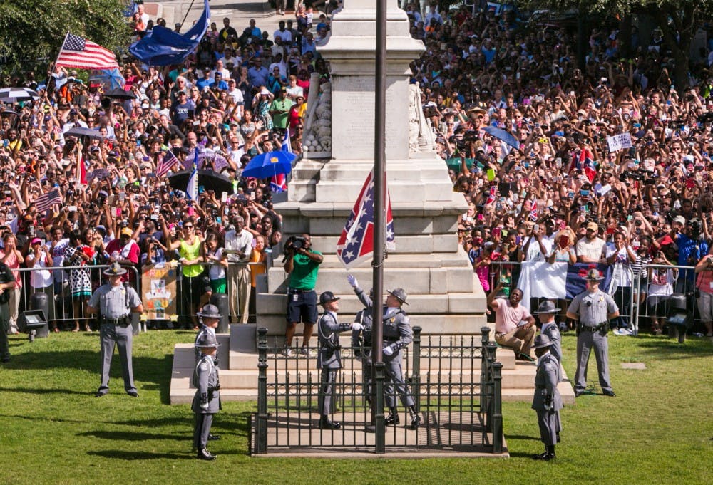 The South Carolina Highway Patrol Honor Guard removes the Confederate Battle Flag from the State House grounds during a ceremony on Friday, July 10, 2015, in Columbia, S.C. (Tim Dominick/The State/TNS)