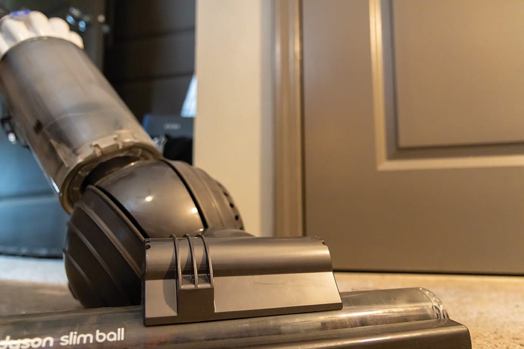 A vacuum cleaning the carpet in an apartment. Using a vacuum with a HEPA filter has increased health benefits.