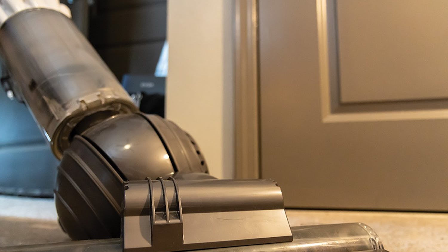 A vacuum cleaning the carpet in an apartment. Using a vacuum with a HEPA filter has increased health benefits.