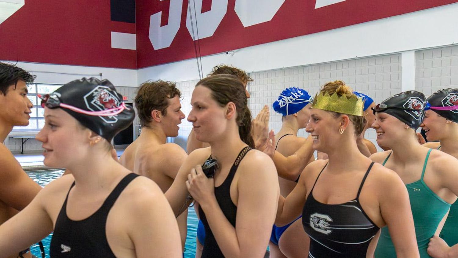 Senior breaststroke and individual medley swimmer Georgia Johnson (right) and teammates congratulate their Duke University and UNC Asheville competitors after the tri-meet on Jan. 20, 2024. The Blue Devils won the meet, beating the Gamecocks and the Bulldogs.