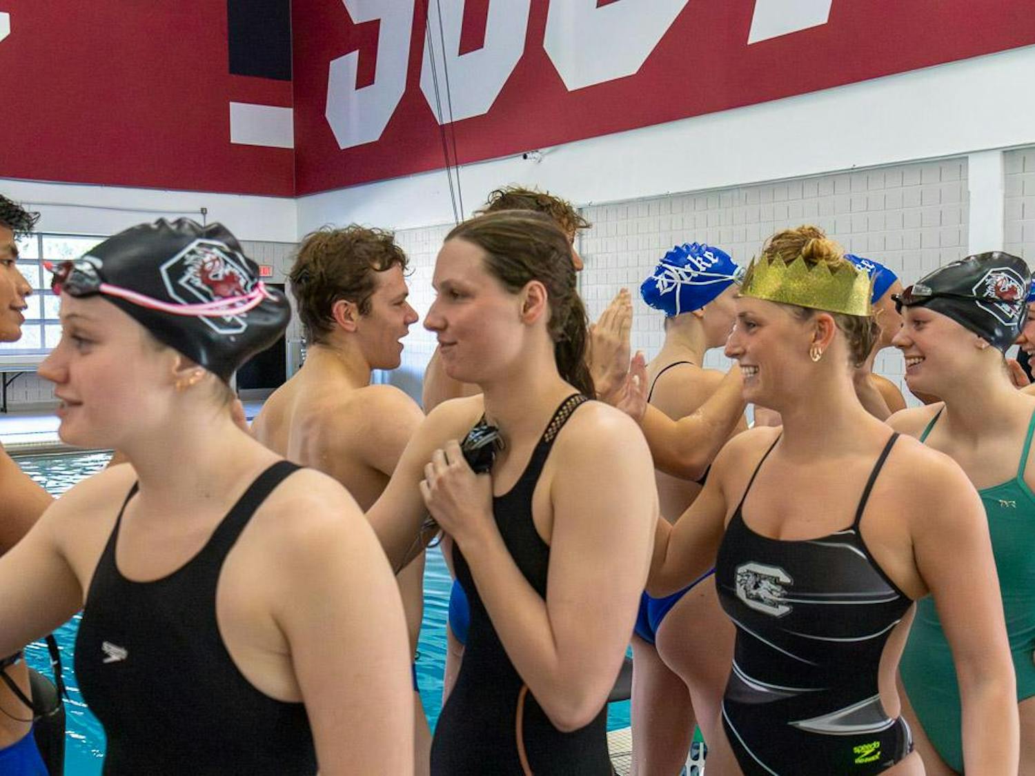 Senior breaststroke and individual medley swimmer Georgia Johnson (right) and teammates congratulate their Duke University and UNC Asheville competitors after the tri-meet on Jan. 20, 2024. The Blue Devils won the meet, beating the Gamecocks and the Bulldogs.