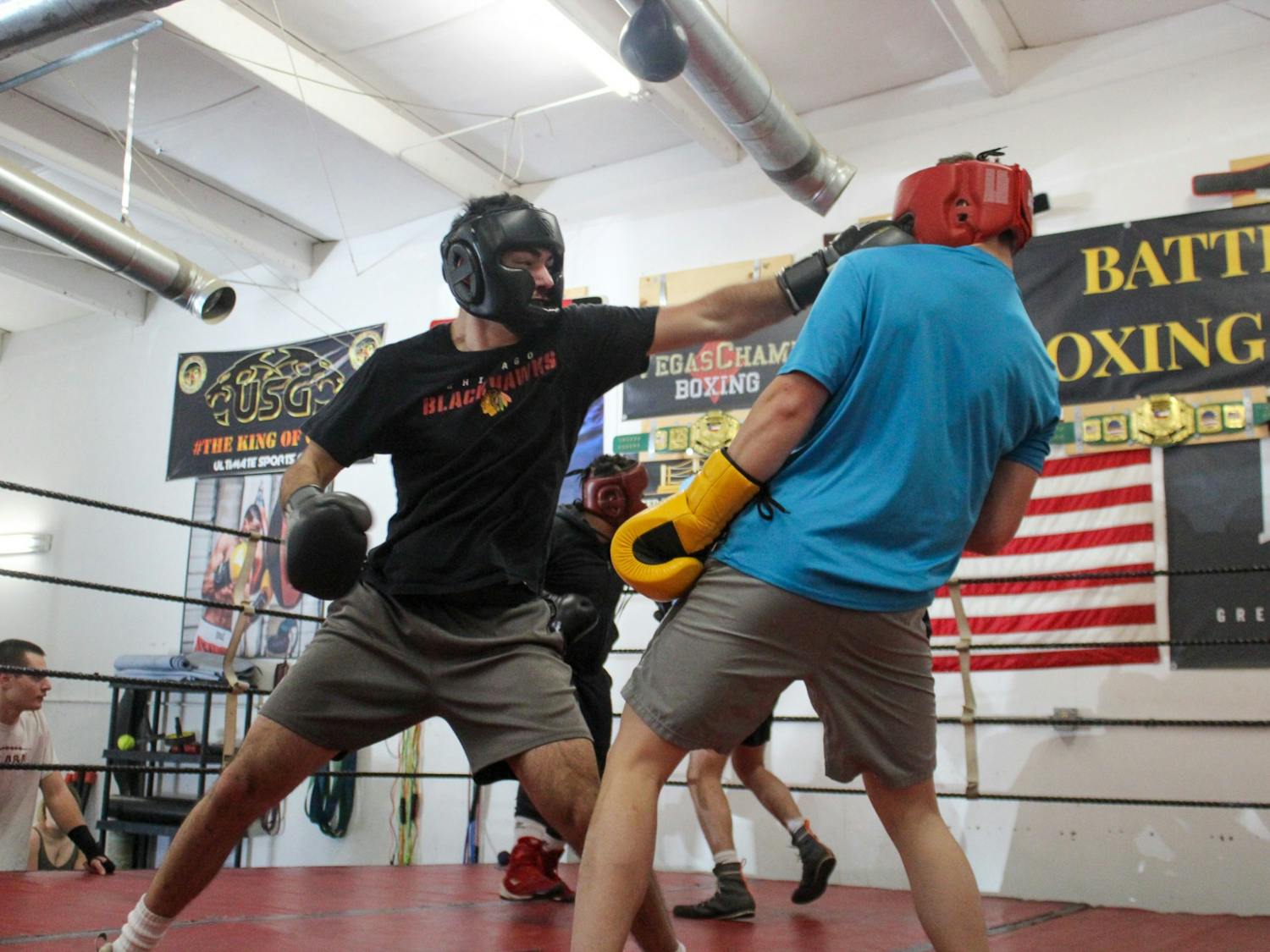 Members of the Carolina Boxing Club trade shots for an advantage in the ring during a sparring practice on Feb. 18, 2022. Boxing club practices include a variety of workouts focusing around cardio, combo training and strength training.