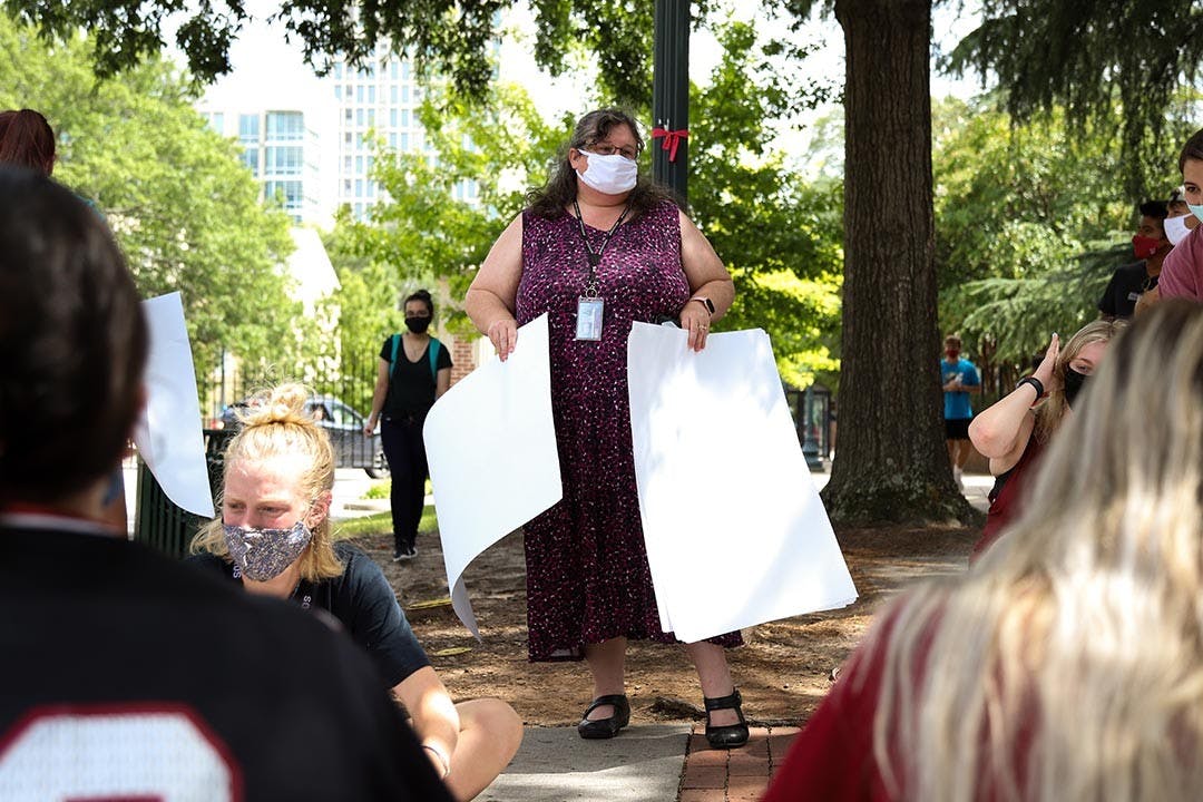 A staff member at the University of South Carolina hands out markers and paper to allow protesting students to make signs to combat Jim Gilles.